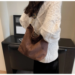 Detail of dark brown suede tote bag with vintage printed wide shoulder strap