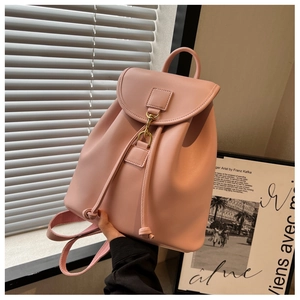 Vue latérale du petit sac à dos en similicuir rose avec boucle dorée et cordon de serrage