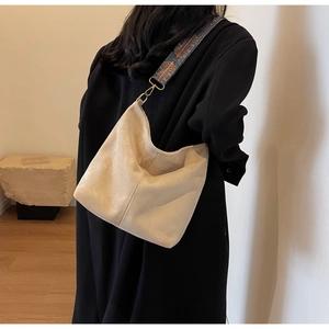 Detail of bohemian patterned wide strap and beige faux suede on a large hobo tote bag