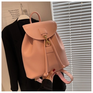 Détail d'un sac à dos rose en cuir avec boucle en métal doré et fermeture à cordon coulissant