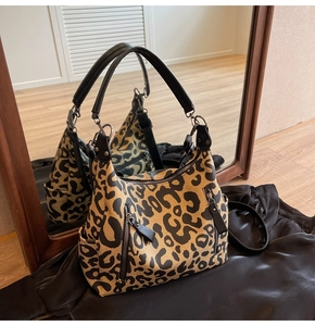 Détail du sac cabas en toile à motif léopard avec fermetures éclair et poches latérales