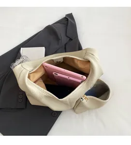 Top view of cream bucket bag with lychee leather texture holding tablet and phone