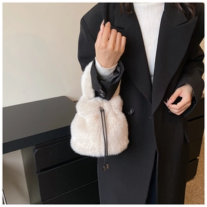 Détail d'un sac seau en peluche avec cordon en cuir et texture douce en fausse fourrure