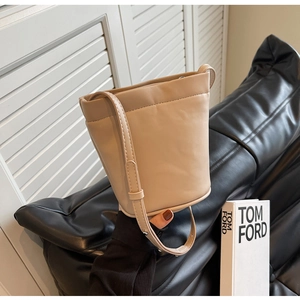 Détail d'un sac seau beige minimaliste en similicuir lisse avec bandoulière réglable