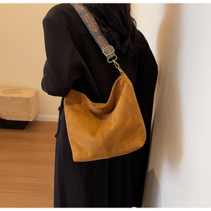 Detail of hobo tote bag with brown suede texture and vintage geometric wide strap