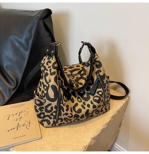 Détail du sac cabas en toile léopard avec poignées en cuir et fermeture éclair latérale