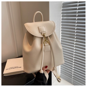 Détail du sac à dos en similicuir crème avec boucle en métal doré et fermeture à cordon
