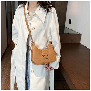 Brown faux crocodile leather half moon crossbody bag with an adjustable shoulder strap