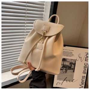 Détail d'un sac à dos en similicuir crème avec fermeture à crochet et ouverture à cordon