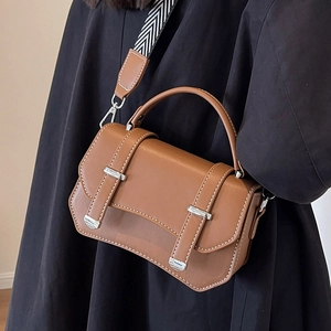 Brown leather crossbody bag with wide geometric woven strap and silver buckles