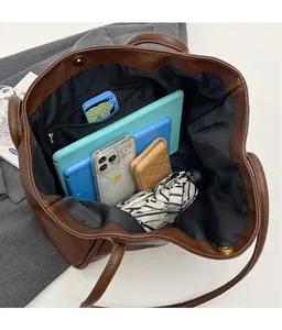 Top view of spacious brown tote bag interior with multiple compartments and magnetic closure
