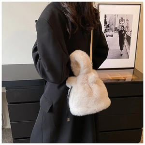 Détail du sac seau en peluche blanc cassé avec une texture douce et un cordon serrage