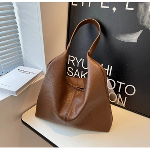 Detail of dark brown lychee textured leather bag with soft slouchy hobo design