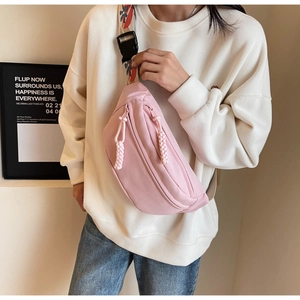 Detailed shot of a pink canvas crossbody bag with adjustable star pattern webbing strap
