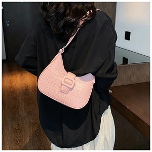 Detail shot of a pink crocodile-textured hobo bag with a stylish square buckle strap