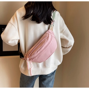 Detailed back view of a pink crescent canvas chest bag with floral jacquard strap