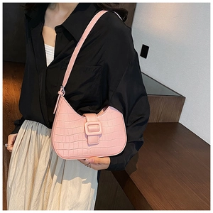 Pink crocodile pattern crescent shoulder bag with adjustable strap on female model