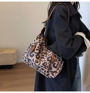 Détail du sac cabas en toile léopard avec lanières en cuir et fermeture éclair latérale