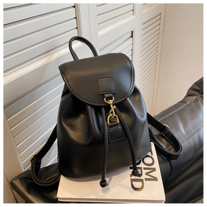 Détail d'un sac à dos en cuir noir avec boucle en métal doré et cordon de serrage