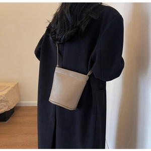 Détail du sac seau kaki minimaliste montrant la texture du cuir et les coutures