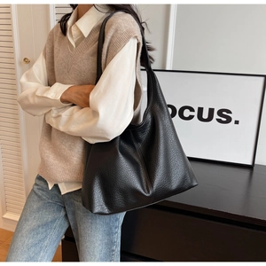 Close-up of black lychee grain leather texture on large capacity commuter tote bag