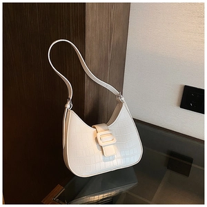 Detail of white crocodile texture on underarm bag with elegant metal square buckle