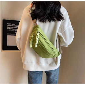 Detail of avocado green crossbody bag with floral jacquard strap and woven zipper pullers