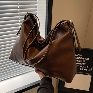 Large dark brown leather tote bag with minimalist design for stylish women commuting