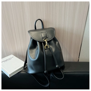 Détail d'un sac à dos en cuir noir avec crochet en métal doré et fermeture à cordon