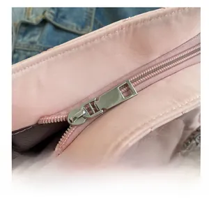 Détail du sac en nylon matelassé rose montrant la fermeture éclair en métal argenté