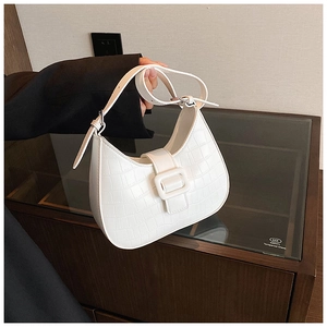 Detail of white crocodile pattern underarm bag with a large metallic square buckle