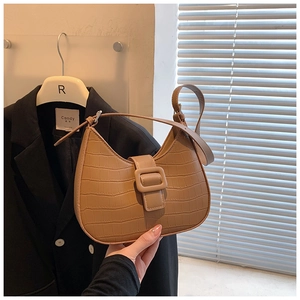 Detail of brown crocodile pattern leather underarm bag with tonal square buckle closure