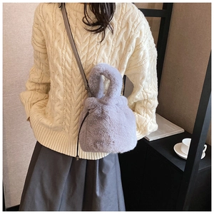 Gros plan du sac seau en fausse fourrure lavande avec bandoulière sur le mannequin
