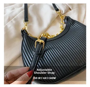 Détail de la bandoulière réglable et texture plissée sur le sac à bandoulière noir