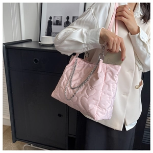 Détail du cabas en nylon rose matelassé avec chaîne argentée et téléphone à l'intérieur