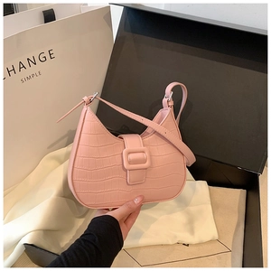 Detailed view of pink croc-embossed hobo bag displayed elegantly on white silk lining