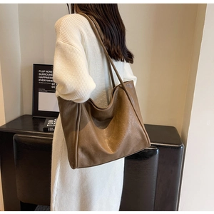 Detail of soft brown textured leather tote bag showing the slouchy style and shoulder strap