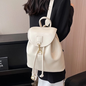 Sac à dos en cuir blanc minimaliste avec boucle dorée présenté sur modèle en vue latérale