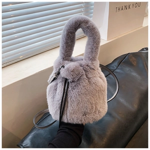 Vue détaillée du sac seau en peluche gris clair avec cordon de serrage et texture douce