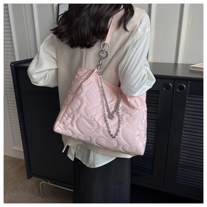 Détail du sac cabas en nylon rose matelassé avec motifs cœurs et bandoulière chaîne