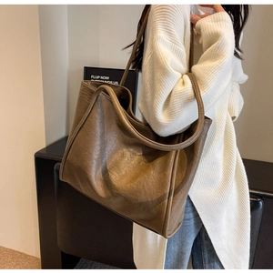 Detail of a large brown tote bag with natural leather texture for daily commute and styling