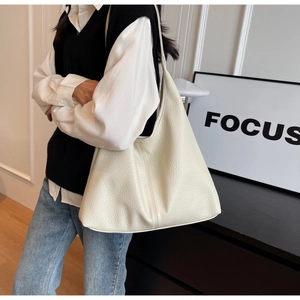 Detailed macro view of white lychee texture on large minimalist hobo shoulder bag