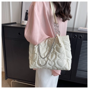 Détail du sac fourre-tout en nylon blanc avec matelassage cœur et bandoulière chaîne