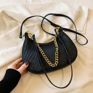 Détail du sac demi-lune plissé noir avec chaîne dorée et bandoulière en cuir