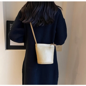 Détail du sac seau crème avec longue tirette en cuir et bandoulière fine en cuir souple