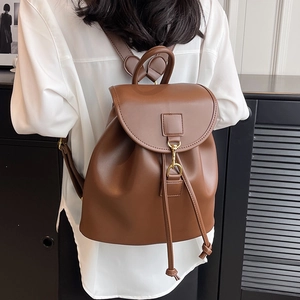 Sac à dos en cuir marron pour femme avec cordon de serrage et boucle dorée sur mannequin