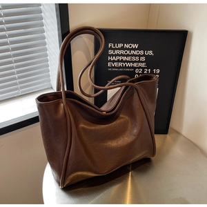 Detail shot of a dark brown tote bag with premium lychee grain texture and minimalist design