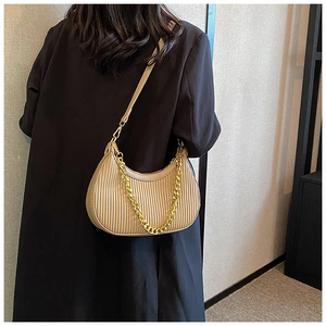 Détail du sac croissant plissé avec texture en cuir mat et bandoulière chaîne dorée