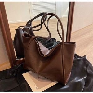 Detailed mirror view of large brown leather tote bag with elegant matte finish