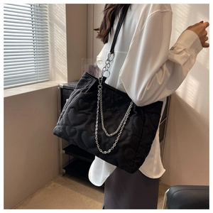 Détail du sac fourre-tout en nylon matelassé avec motif cœur et bretelles à chaînette